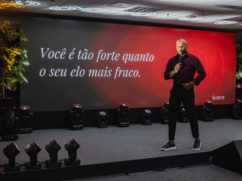 Thiago Mancussi no palco diante do telão do Home Care Experience