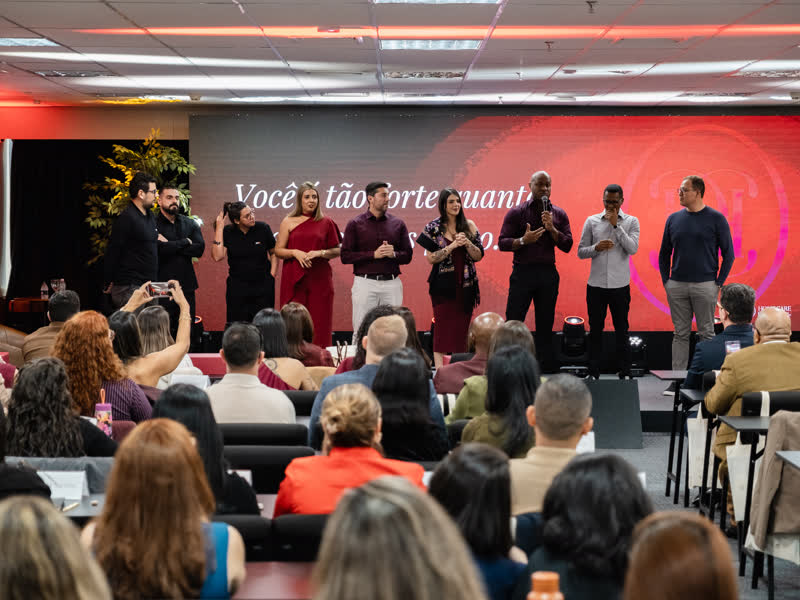 Equipe do Home Care Club reunida no palco diante dos participantes